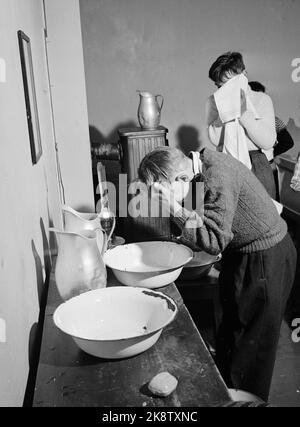 Nordkapp på Magerøya 195210. Europas nordligste internatskole ligger på Nordkapp i Repvåg ytterst i Porsangerfjorden. Åtte småsteder var skoleskøyta innom for å hente små passasjerer Fra 7 års alderen. Et par AV plasse hadde kai så skøyta kunne gå helt Inn, men som regel måtte den ligge utpå Og vente på robåten med ungen Og kofferten. Nordkapp herred--kommunen har skoleinternat for barna som bor på små avsidesliggende plasser innenfor herredsgrensene. Det er unger Fra anslagsvis 75 familier. Her ser vi elevene vasker seg i ansiktet i vaskevannsfat. Vannmugger står på bordet ved Fatet. Foto: Stockfoto