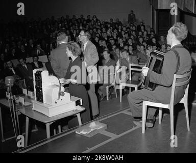 Oslo 1955 NRK Radio hat einen großen Erfolg mit dem Fragebogen "die Frage" von dem großen Glas Rolf Kirkvaag geführt. Das Konzept ist einfach und die Preise sind bescheiden, aber die Stimmung im Studio ist am Siedepunkt! ALF Blyverket stellt die Musik und die Kasse Jonatan für die Auszahlungen zur Verfügung. Im Hintergrund Kirkvaag (TV) mit einem der Kandidaten. Foto: Storløkken / Aktuell / NTB Stockfoto