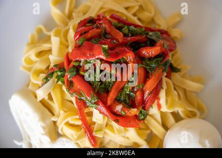 Paprika-Pasta mit Käse und Eiern auf dem Teller serviert Stockfoto