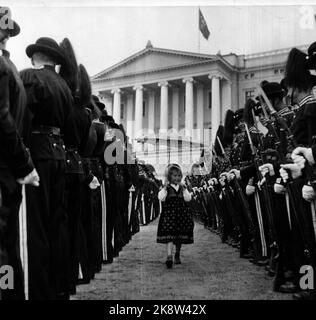 Oslo. König Haakon 80 Jahre 3. August 1952. Das Bild: Ein kleines Mädchen hat sich zwischen Reihen strenger Wächter auf dem Schlossplatz verloren. Sie hat einen Regenschirm, um den Bunad am besten auszusehen. Jetzt wartet sie nur noch darauf, dass der König von der Fahrt zurückkommt. Foto: Sverre A. Børretzen / Aktuell / NTB Stockfoto