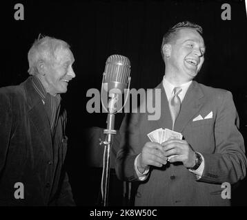 Oslo 1955 NRK Radio hat einen großen Erfolg mit dem Fragebogen "die Frage" von dem großen Glas Rolf Kirkvaag geführt. Das Konzept ist einfach und die Preise sind bescheiden, aber die Stimmung im Studio ist am Siedepunkt! Hier jubelt Kirkvaag, kr übergeben zu können. 80.- bis 79 Jahre alt E. Seland. Er beantwortete vier Fragen richtig und entpuppte sich als Geografie. Großes, altmodisches Mikrofon in der Mitte des Bildes. Foto: Storløkken / Aktuell / NTB Stockfoto