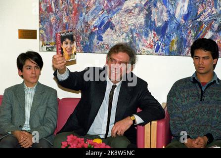 Oslo 19911209. Friedensnobelpreis 1991 an Aung San Suu Kyi, Oppositionspolitikerin in Burma. Aung San Suu Kyi befindet sich seit 1989 in Hausarrest, nachdem sie die Opposition gegen einen überlegenen Wahlsieg angeführt hatte, der vom Militär nie respektiert wurde. Die Auszeichnung wird von der Familie des Friedenspreisträgers, Ehemann Michael Aris und den Söhnen Kim und Alexander Aris entgegengenommen. Das Bild: Michael Aris und die Söhne Kim (v.v.) und Alexander bei einer Pressekonferenz bei der Ankunft in Oslo. Michael Aris zeigt ein Buch über Aung San Suu Kyi. 26905 Foto: Bjørn Sigurdsøn/NTB Stockfoto