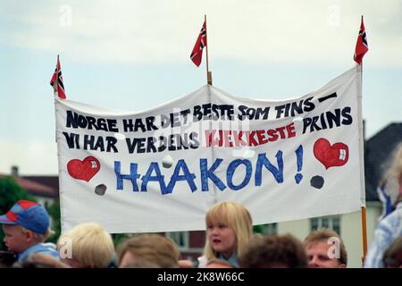 Kristiansand 19910627. - 1991. Juni. Die königliche Familie in Kristiansand. Zuschauer mit Transparent, auf dem steht: „Norwegen hat das Beste zu tun – wir haben den schönsten Prinzen der Welt, Haakon“. Foto: Lise Åserud / NTB Stockfoto