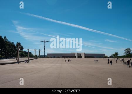 Fatima, Portugal, 23.09.202 - Heiligtum von Fatima, Portugal. Gebetssaal mit dem Hohen Kreuz und der Basilika der Heiligen Dreifaltigkeit im Hintergrund. Stockfoto