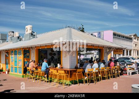 Menschen, die in einer Taco-Bar oder einem Taco-Standrestaurant im Freien im Ferienort Seaside Florida, USA, bestellen und essen. Stockfoto
