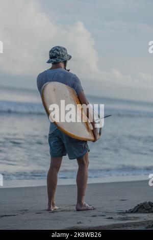 Surfer trägt Board, während Sie den Horizont betrachten Stockfoto
