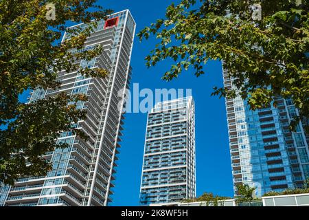 Neuer moderner Hochhausapartmentkomplex in Vancouver, BC. Von unten nach oben Blick auf neue moderne Wohngebäude. Wolkenkratzer aus dem niedrigen Winkel im Modder Stockfoto