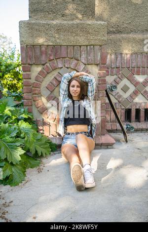 Skateboarderin Girl sitzt vor einem Gebäude in SJSU Stockfoto