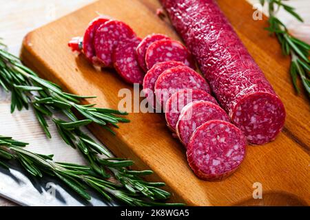 Getrocknete Wurst auf Schneidebrett. Traditionelles spanisches Fleischprodukt Stockfoto