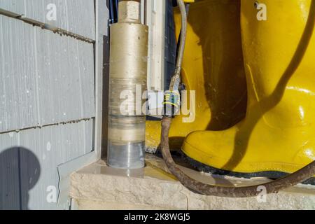 Bohren von Loch auf Beton mit Industriebohrmaschine auf der Baustelle Stockfoto