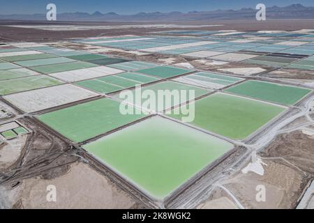 Atacama, Chile. 24. Oktober 2022. Salzwasserbecken mit Lithiumcarbonat und Haufen von Nebenprodukten, die in der Atacama-Wüste im Salar de Atacama verstreut sind. Die Sociedad Química y Minera de Chile (QM) baut ihre Bergbauaktivitäten aus, um der wachsenden weltweiten Nachfrage nach Lithiumcarbonat, dem Hauptbestandteil bei der Herstellung von wiederaufladbaren Batterien, zunehmend für Elektrofahrzeuge, gerecht zu werden. Kredit: Lucas Aguayo Araos/dpa/Alamy Live Nachrichten Stockfoto