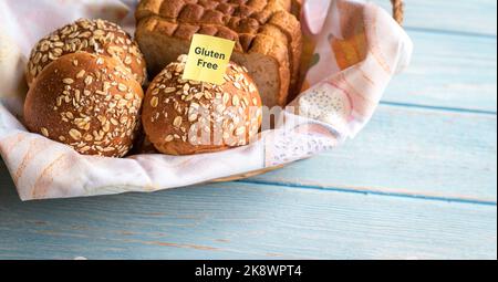 Glutenfreies Etikett auf Korb mit frisch gebackenem Brot und Brötchen. Speicherplatz kopieren. Stockfoto