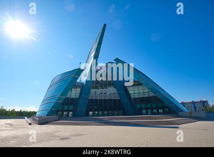 Ein Blick auf die blumenförmige, moderne, geschwungene blaue, grüne Glasfassade. In der kasachischen Konzerthalle in Astana, Nursultan, Kasachstan. Stockfoto