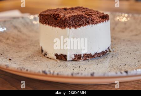 Kuchen mit Schokolade und Eis auf dem Teller im Café Stockfoto