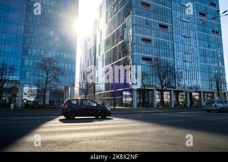 Danzig Polen - Mai 2022 Sun geht durch die Wolkenkratzer-Szene des öffentlichen Verkehrs in Danzig. Oliva Geschäftsviertel Transport Stadtverkehr. Straßenbahnen Busse Autos City Traffic Jam. Stadtleben Stockfoto