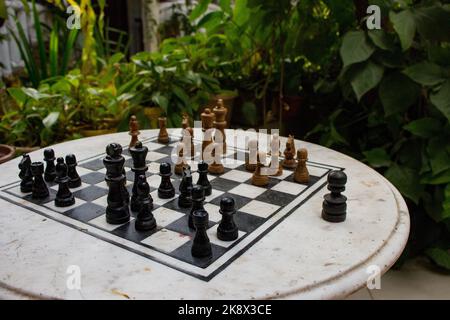 Outdoor-Schachbrett mit Figuren. Wettbewerbs- und Strategiekonzept. Intelligenter Sport. Konzept „Niederlage und Kampf“. Schach Holzstücke an Bord. Stockfoto