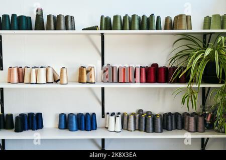 Wir haben jeden möglichen Schatten, den Sie sich vorstellen können. Garnspulen auf einem Regal. Stockfoto