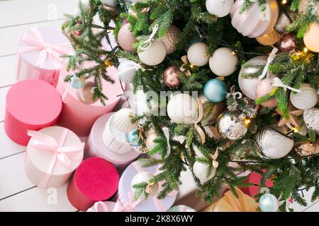 Schöner festlich dekorierter Raum mit Weihnachtsbaum und hellem Feuer mit Geschenken, selektiver Fokusaufnahme. Verschwommenes weihnachtsfest und Stimmung im neuen Jahr Stockfoto
