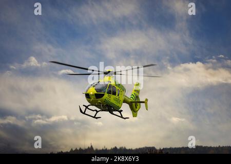 FinnHEMS, Finnish Helicopter Emergency Medical Services, medizinischer Hubschrauber hebt in der Stadt gegen den dramatischen Himmel ab. Stockfoto