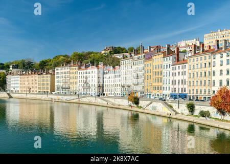 Französische Stadt an einem sonnigen Tag mit einer Straße am Fluss Stockfoto