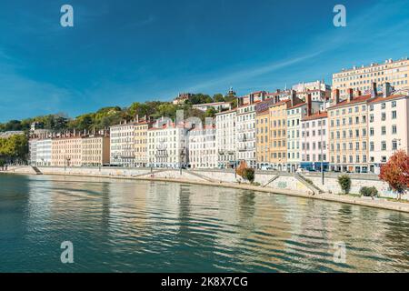 Französische Stadt an einem sonnigen Tag mit einer Straße am Fluss Stockfoto