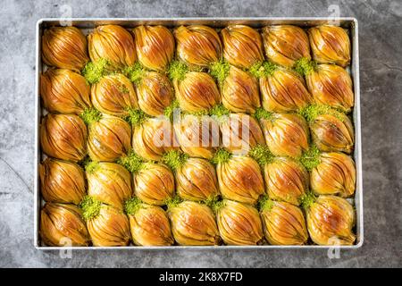 Muschel Baklava mit Pistazie. Tray Baklava auf dunklem Hintergrund. Traditionelle türkische Küche Delikatessen. Nahaufnahme Stockfoto