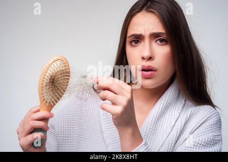 Haarausfall Frau mit einem Kamm und Problemhaar. Haarausfall gestresste Frau und kahle Probleme. Stockfoto