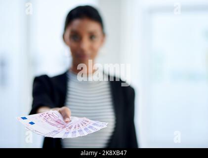 Akzeptieren Sie Barzahlungen? Unverschämter Schuss einer jungen Geschäftsfrau, die bei der Arbeit einen Stapel Geld in ihrem Büro hält. Stockfoto
