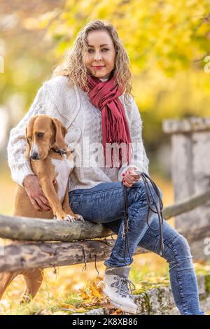 Porträt einer jungen Frau im Herbst-Outfit mit ihrem Haustier. Stockfoto