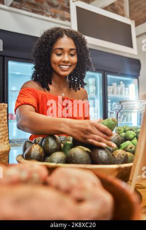 Schwarze Frau im Supermarkt, Lebensmitteleinkäufe und Avocado, Kunden und Einzelhandel, Gemüse frisches Produkt und den Kauf von Lebensmitteln im Geschäft. Jung, Afrikanisch Stockfoto