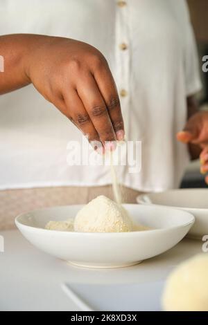 Nahaufnahme der hände einer kubanischen Frau, die Kartoffelpüree paddeln. Stockfoto