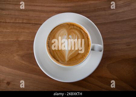 Tasse Cappuccino auf Holztisch, Draufsicht Stockfoto