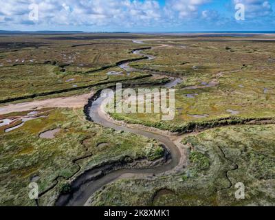 Eine Drohnenaufnahme von Salzmarschen im Dorf Stiffkey unter einem bewölkten Himmel Stockfoto