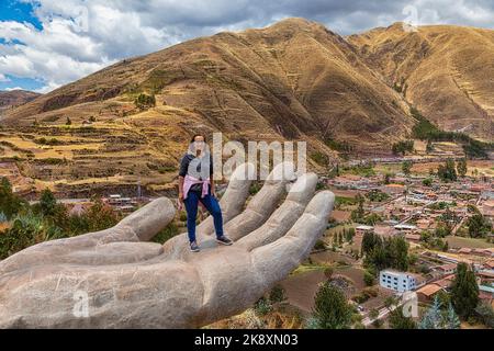 Eine Frau am Aussichtspunkt Mirador de Cielo Punku in Huaro, Cusco, Peru. Dieser Aussichtspunkt besteht aus zwei Händen, die bis ins Tal reichen. Stockfoto