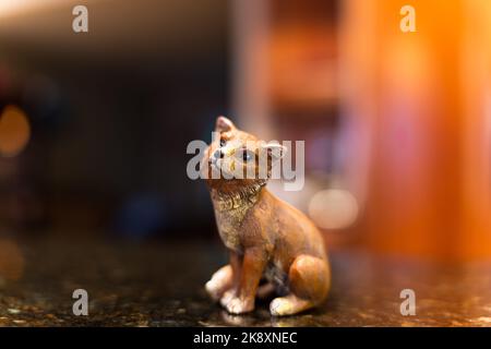 Eine Nahaufnahme einer entzückenden kleinen Statue eines Fuchses auf einem schwarzen Tisch Stockfoto