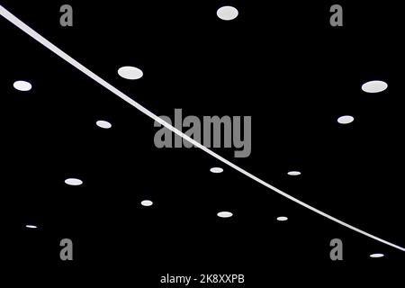 Punkte und Lichtlinien, die durch eine Lampe auf schwarzem Hintergrund entstehen. Heller LED-SMD-Bildschirm. Technologischer oder elektronischer konzeptioneller Hintergrund. Stockfoto