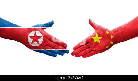 Handschlag zwischen China und Nordkorea Flaggen auf Händen gemalt, isolierte transparente Bild. Stockfoto