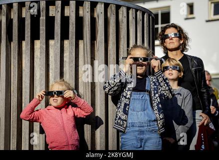 2022-10-25 11:42:57 UTRECHT - Besucher des Sonnenborgh Museums sehen eine partielle Sonnenfinsternis mit einer Sonnenfinsternis-Brille. Die Sonne ist zum Teil hinter dem Mond verborgen, was den Anschein hat, als würde der Sonne ein Bissen genommen. ANP ROBIN VAN LONKHUIJSEN niederlande Out - belgien Out Stockfoto