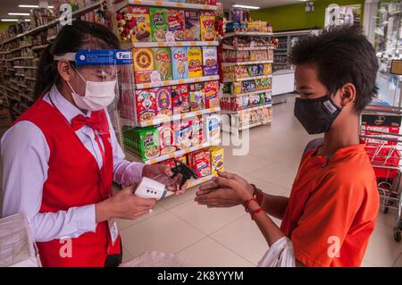 Während eines Ausbruchs von COVID - 19, bekommt ein Teenager-Junge mit gemischter Rasse (Kambodschanisch - Amerikaner), Phnom Penh, Kambodscha, seine Hände desinfiziert. © Kraig Lieb Stockfoto