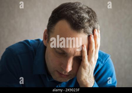 Junger, müder Kaukasischer Mann mit Kopfschmerzen, Nahaufnahme des Studioportraits Stockfoto
