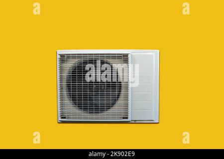 Wärmepumpe Außengerät auf gelbem Hintergrund isoliert. Stockfoto
