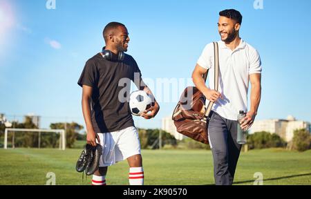 Fußball, Training und Freunde, die nach dem Training, Spiel und Fußballspiel auf dem Feld laufen. Vielfalt, Fitness und Männer glücklich nach dem Training, Training und Stockfoto