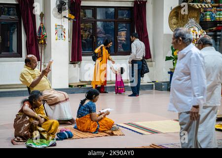 Hinduistische Anhänger rezitieren Tirumuruk???Uppa?ai, ein andachtes tamilisches Gedicht in der Sangam-Literatur, das Lord Murugan gewidmet ist. Diwali, Deepavali oder das Festival of Lights ist ein fünftägiges Fest, das von Millionen von Hindus, Sikhs und Jains weltweit gefeiert wird. Es ist an der Zeit, den Triumph des Guten über das Böse und das Licht über die Dunkelheit zu feiern. In diesem Jahr fällt Diwali auf den 24.. Oktober 2022. Eifrige Anhänger besuchen in der Nacht von Diwali den Murugan-Tempel auf dem Highgate Hill, um Puja- oder Anbetungsrituale zur Andacht an ihre verehrten Gottheiten anzubieten. Stockfoto