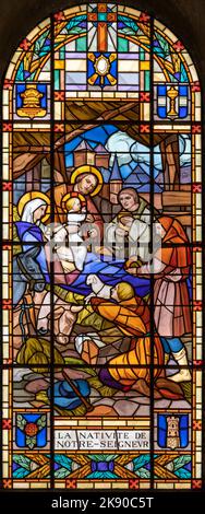 ANNECY, FRANKREICH - 11. JULI 2022: Die Geburt - Anbetung der Hirten in der Glasmalerei der Kirche Notre Dame de Lellis von L. Balmet (1933). Stockfoto