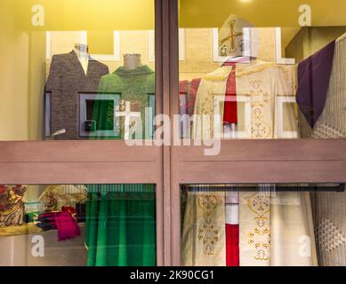 VATIKANSTADT, VATIKAN - 23. DEZEMBER 2015: Liturgische Kleidung in einem Schaufenster in der Vatikanstadt für katholische Priester. Stockfoto