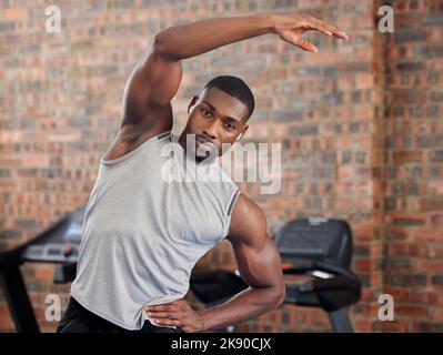 Übung, Black man und Stretching für Training, Fitness und Wellness gesund sein, in Sportbekleidung und im Fitnessstudio mit Fokus Gesicht. Afroamerikanischer Trainer Stockfoto
