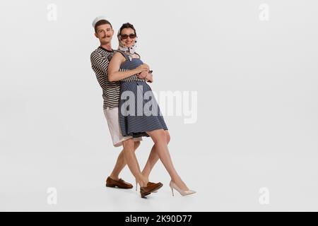 Porträt eines jungen Matrosen in gestreiftem Hemd tanzen mit schönen jungen Frau isoliert auf weißem Hintergrund Stockfoto