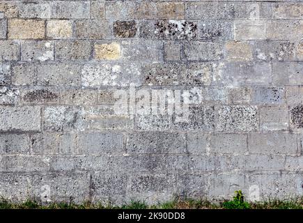 Alte verwitterte Wand aus grauen Ziegeln. Stockfoto