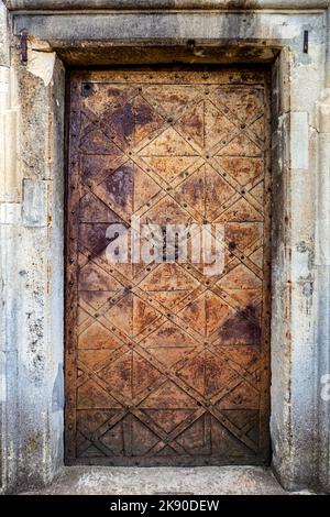 Alte mittelalterliche Metalltür mit Türklopfer. Stockfoto