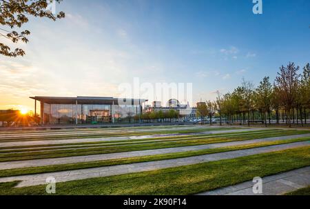 BERLIN, DEUTSCHLAND - 3. MAI 2016 : das Bundeskanzleramt mit bunten Bäumen bei Sonnenaufgang. Es ist der Sitz der deutschen Dose Stockfoto